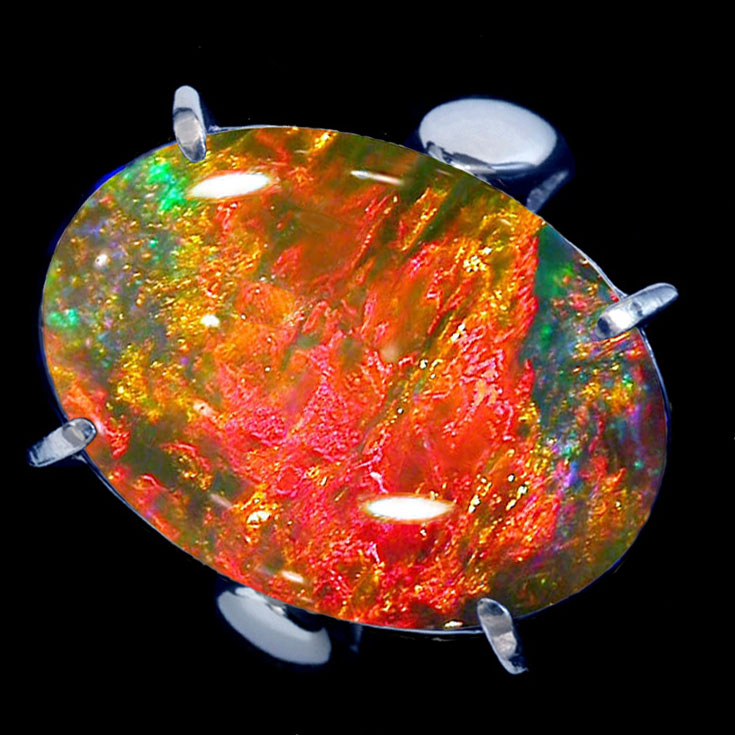 Cómo las rocas y los minerales juegan con la luz para producir colores impresionantes 3 Ópalo de forma ovalada sobre fondo negro.
