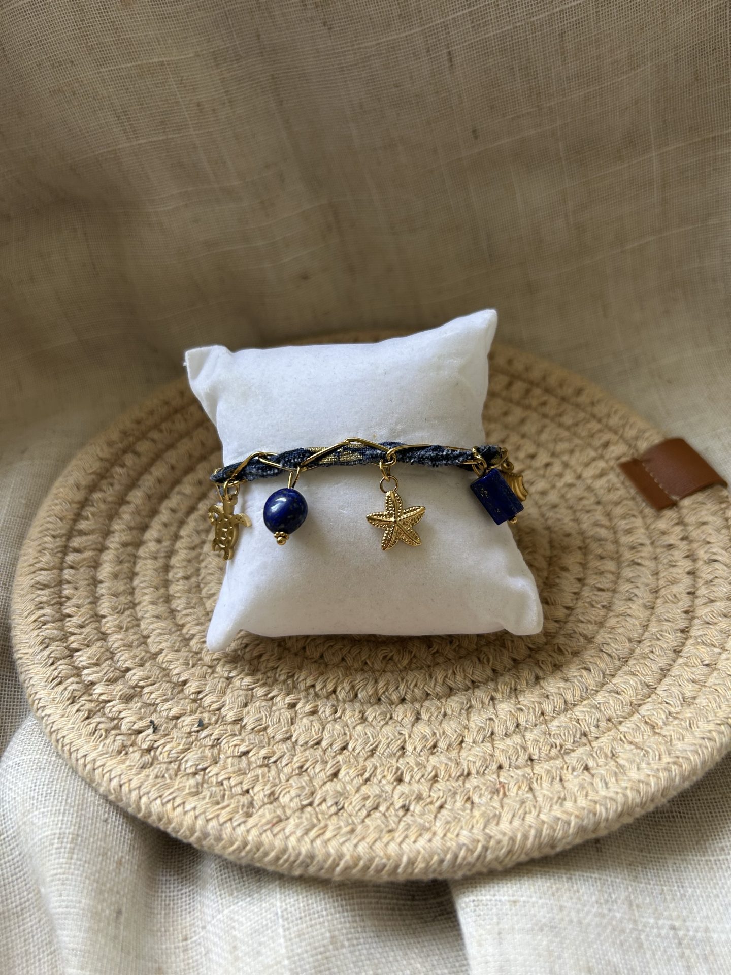 Bracelet Mystérieuse porté, ruban bleu marine et breloques bord de mer