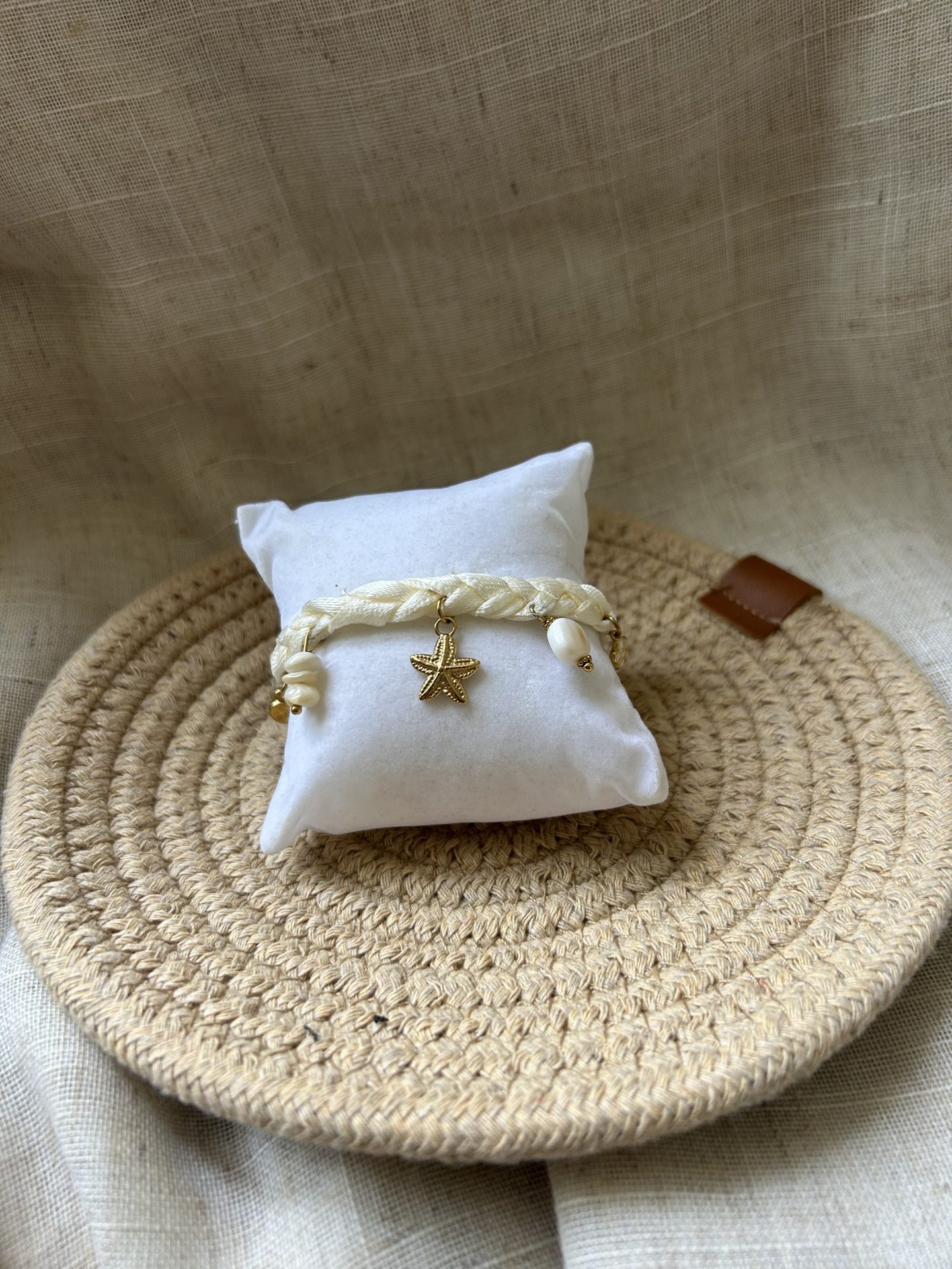 Bracelet épuré sur portant, breloques marines et ruban blanc cassé