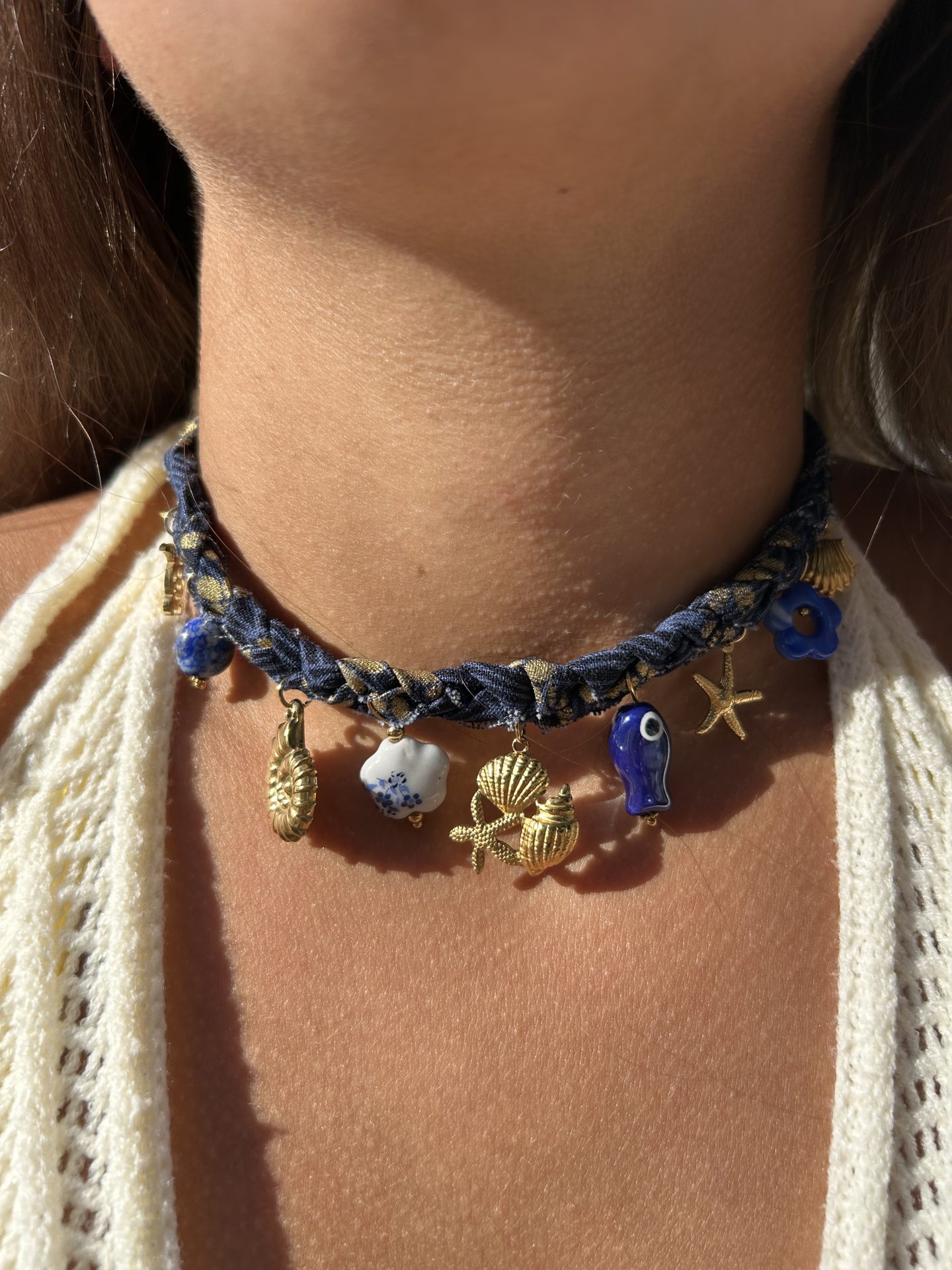 Collier Mystérieuse porté, ruban bleu marine et breloques bord de mer