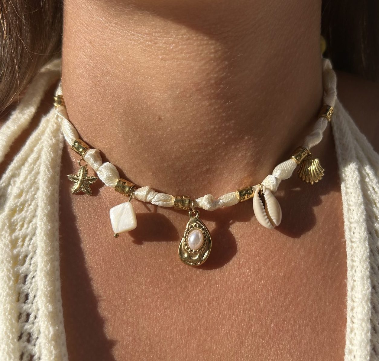 Collier Épuré porté, breloques marines et ruban blanc cassé