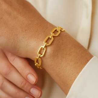 jonc rigide en maillons métalliques dorés porté au poignet sur peau claire