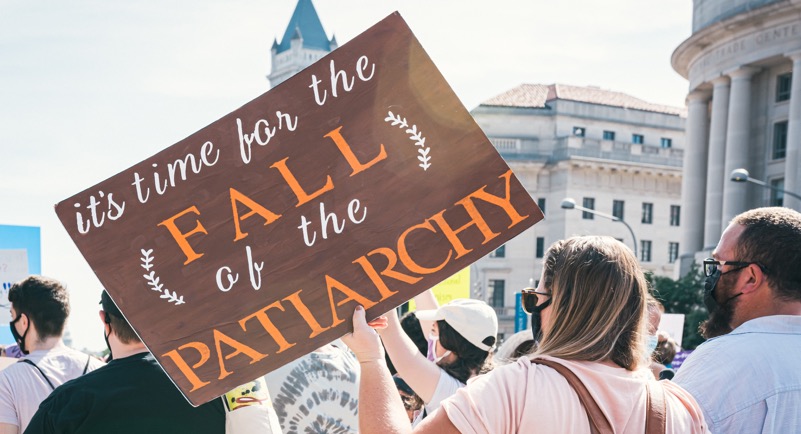 In an article about patriarchy, this is a photo of a crowd marching with a sign that says, "it's time for the fall of the patriarchy."