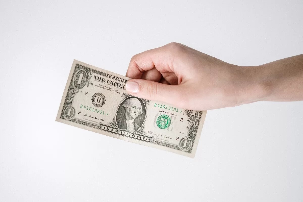 A hand holding a dollar bil