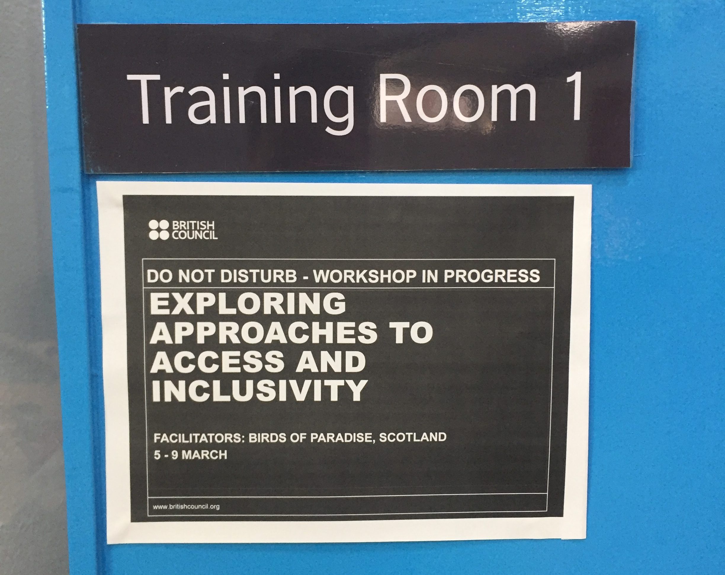 A photo of a blue door that reads 'Training Room 1'. Underneath this there is a British Council sign that reads 'Exploring approaches to access and inclusivity' .