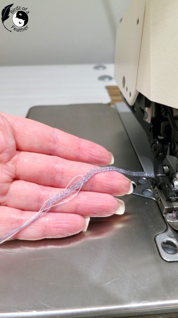 Hand holding blue serger thread showing end result of how to change serger thread