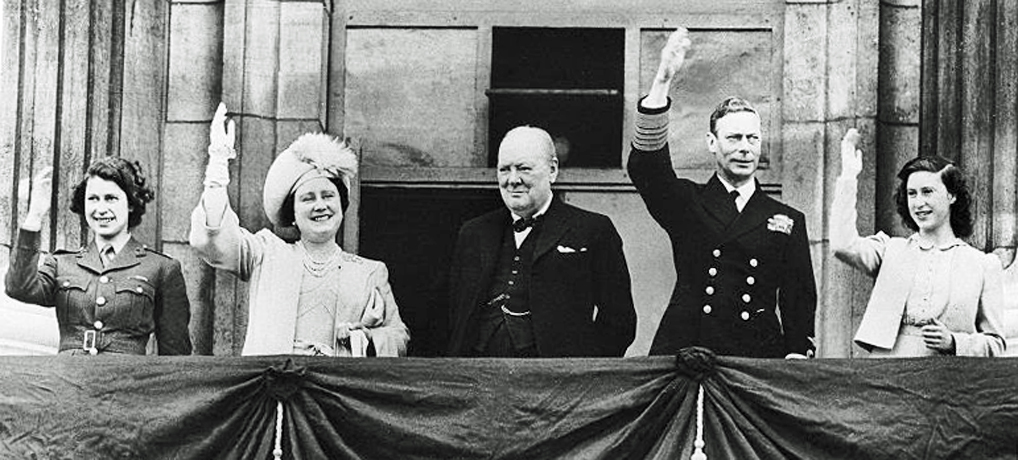 Princess Elizabeth, Queen Elizabeth, Churchill, George VI and Princess Margaret waving to the crowds from Buckingham Palace, 8 May 1945. Photo via WW2 Db. VE Day, Buckingham Palace