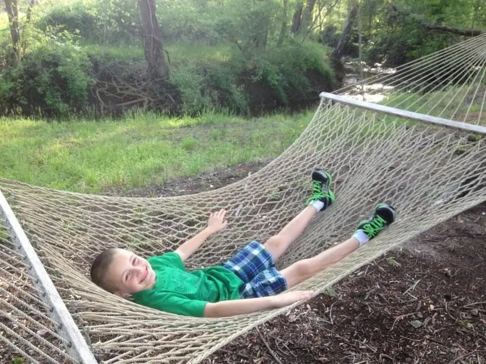 Child Relaxing In A Hammock Outdoors.