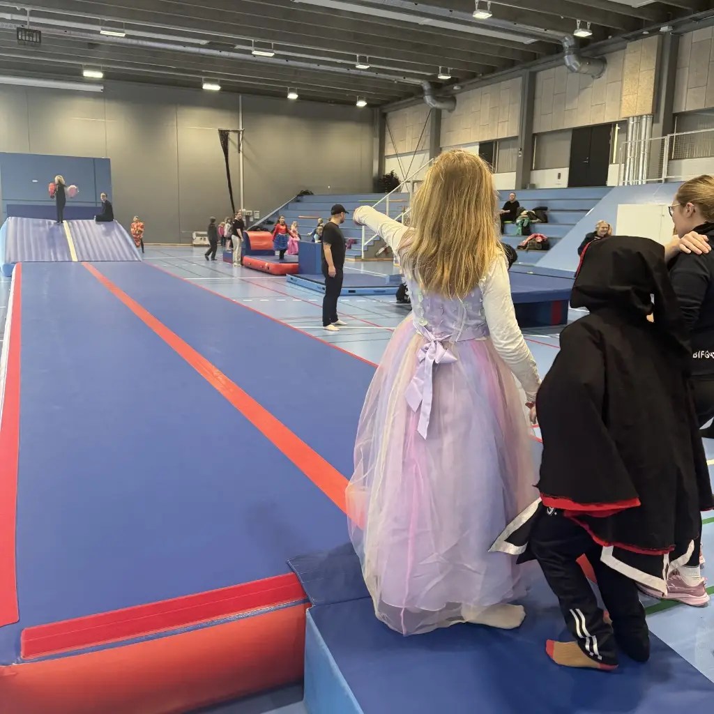 Børn i fastelavnskostumer leger og hopper på springbanen i idrætshallen til Børnedag i Bjerringbro Idræts- & Kulturcenter.