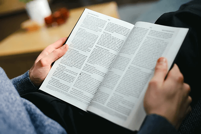 Hands holding an open Bible