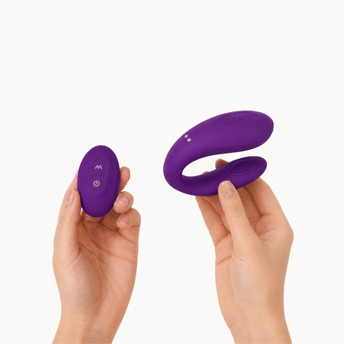 Hand showcasing Embrace vibrator against a light grey background.