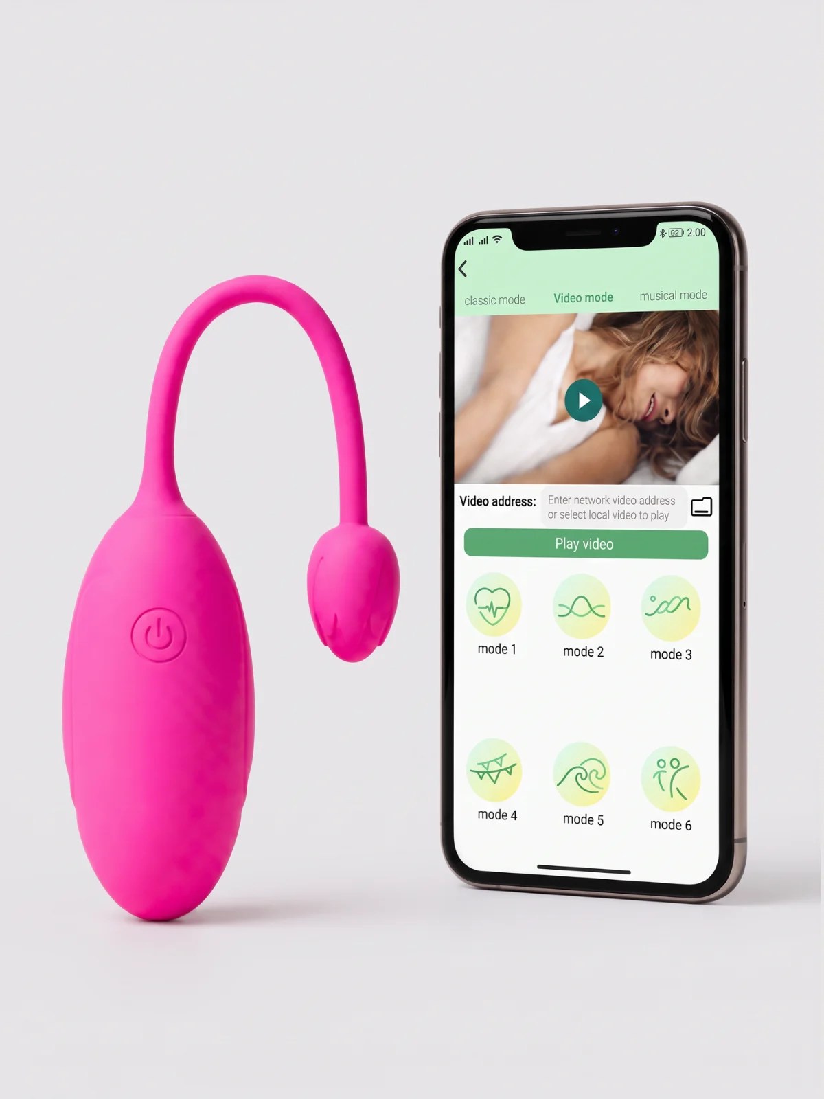Lover Link pink app-controlled wearable vibrator with a flexible arm, displayed beside a smartphone showing video and music control modes.