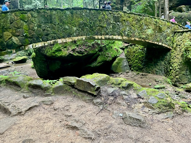 Stone bridge over the gorge along the Old Man’s Cave Loop Trail in Hocking Hills State Park, surrounded by moss-covered rocks, sandstone cliffs, and lush forest.