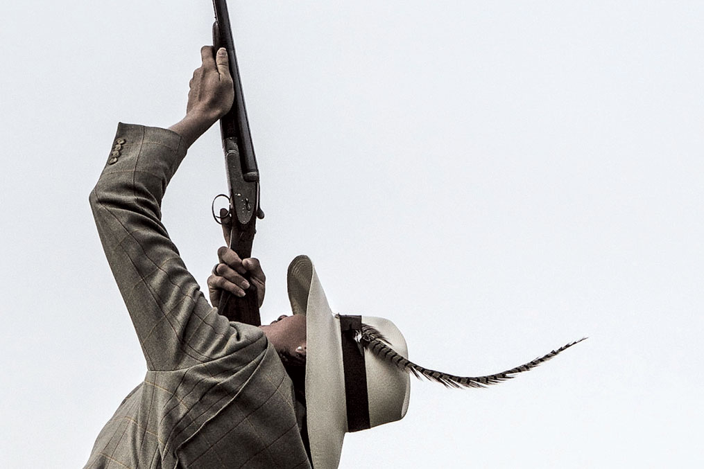 Jen Magnusson aiming a shotgun skyward
