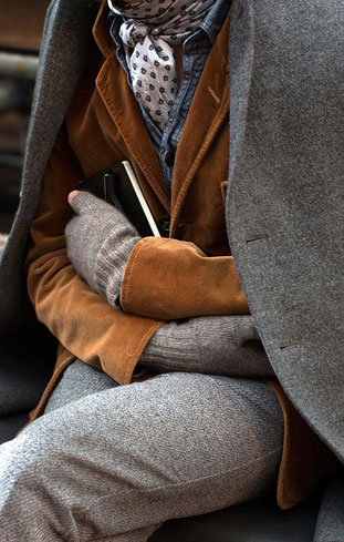 Layered tweed field outfit with leather gloves and a patterned scarf