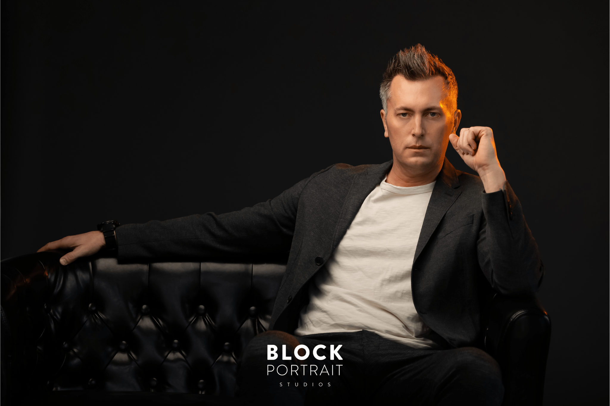 Men's business headshot of a Caucasian man, wearing a cream toned t shirt with a black blazer over top at Block Portrait Studios who specializes in Men's Business Headshots.