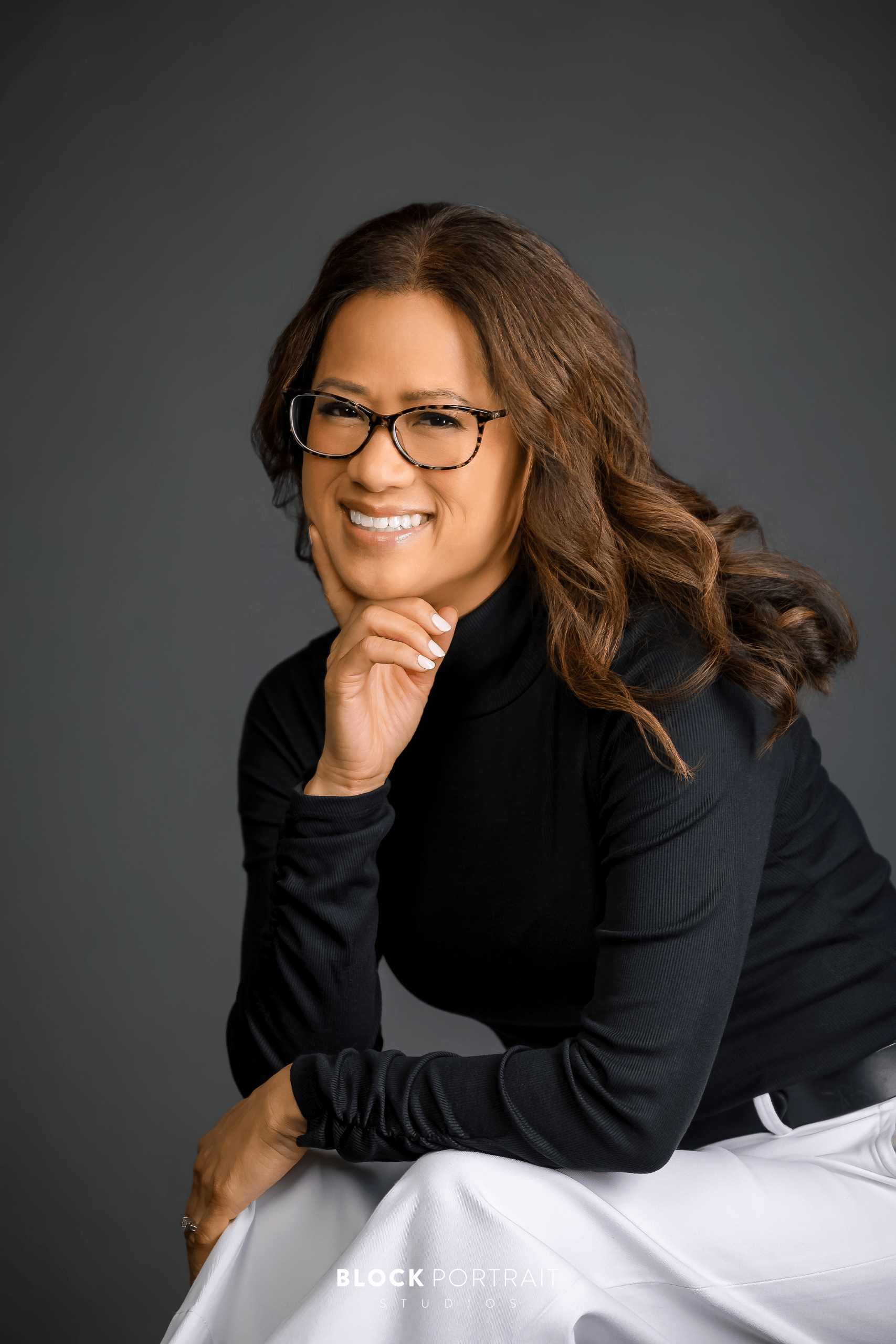 Professional branding portraits in-studio of woman wearing black sweater and white slacks. Portraits by Block Portrait Studios in St. Paul.