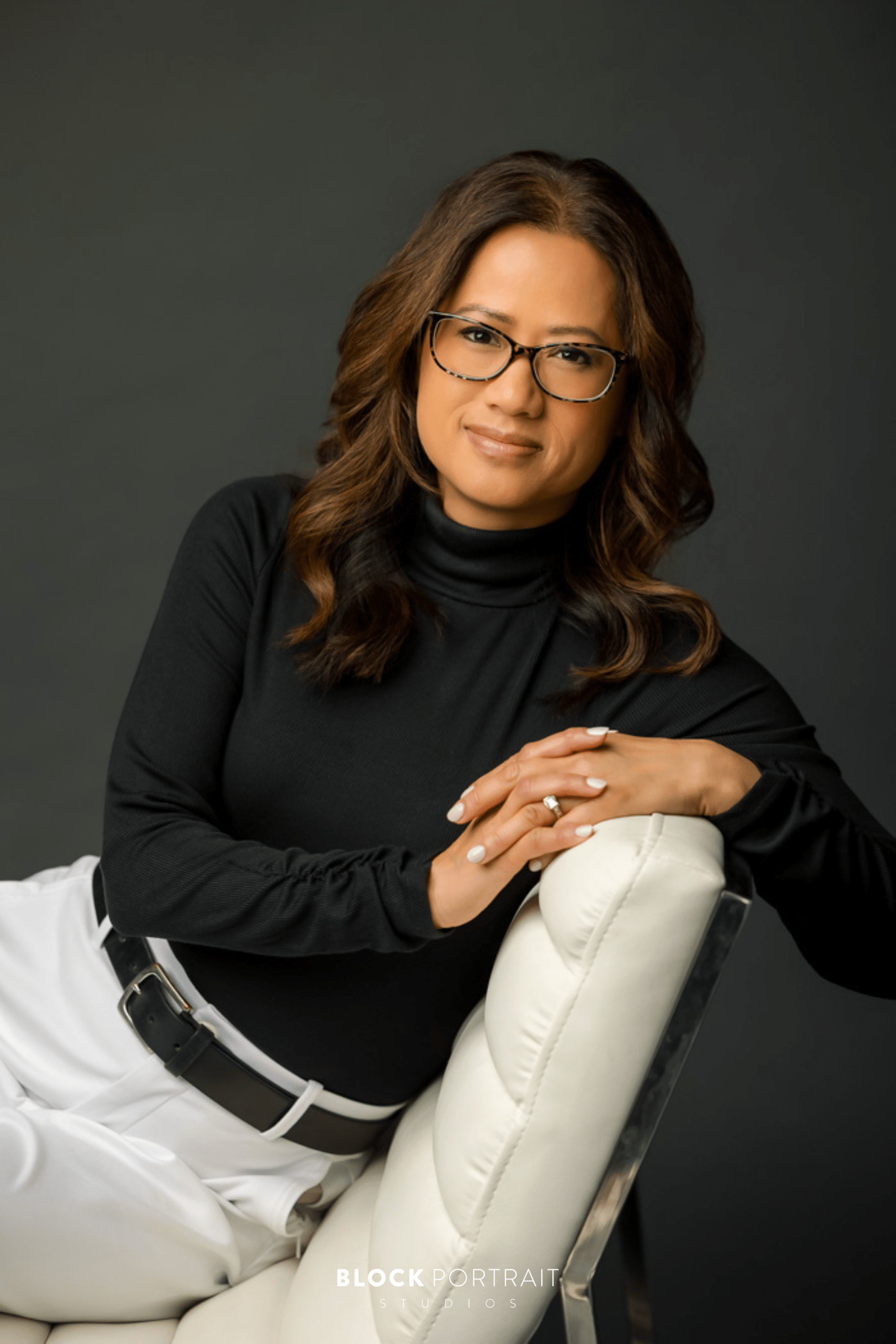 Professional branding portraits in-studio of woman wearing black sweater and white slacks. Portraits by Block Portrait Studios in St. Paul.