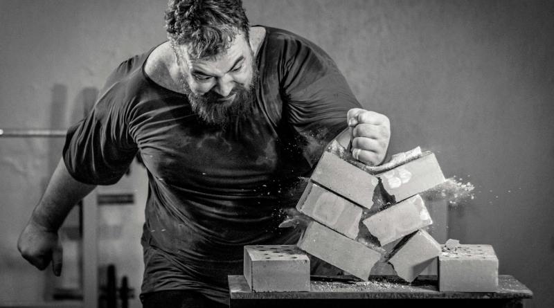 a man breaking concrete block using his hand