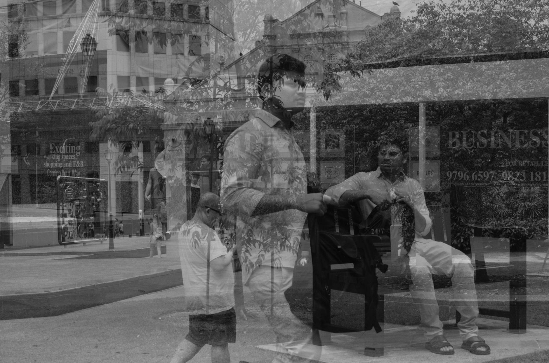 man walking holding backpack and sitting on bench reflection on glass