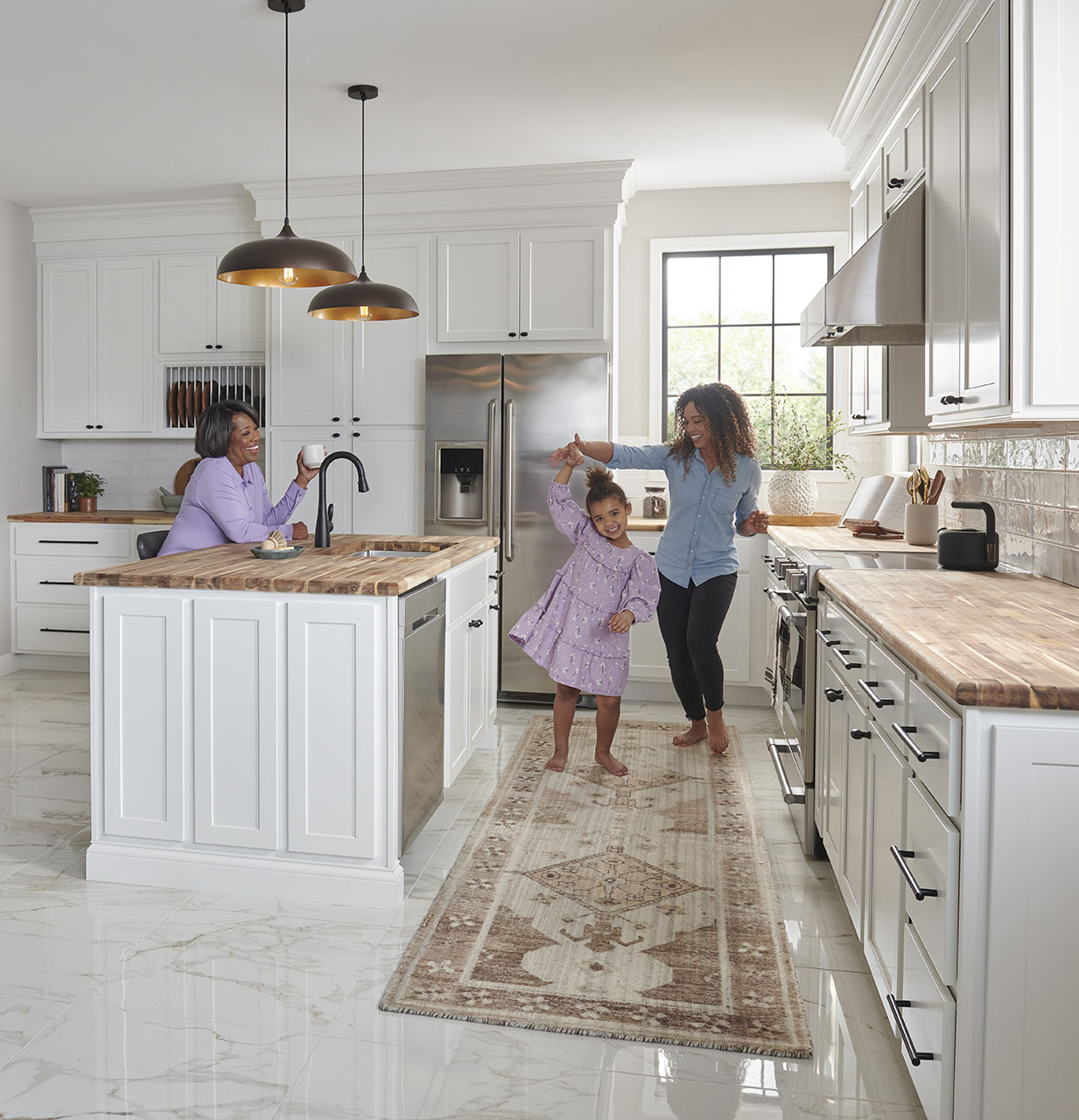 Bright kitchen designed for multigenerational living with family members gathered around a large island.
