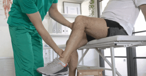 GIF - short video clip of a physical therapist examining a man's leg for range of motion