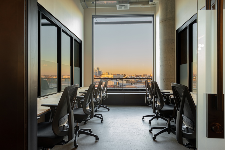 Sunlit coworking space at Mindspace Williamsburg, 25 Kent Avenue, showcasing open layouts, floor-to-ceiling windows, and rooftop views of Manhattan.