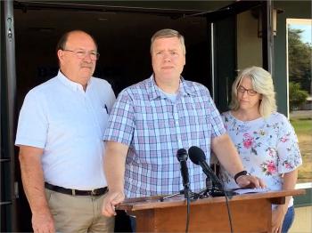 Pastor David George, flanked by his wife and the Oakville, Washington, fire chief