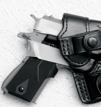 handgun with masking tape around it inserted into a black leather holster