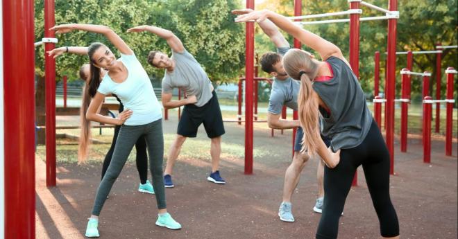 Grup de oameni într-un parc executând exerciții fizice