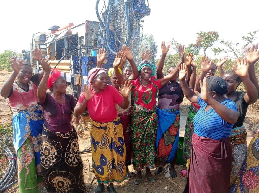 Villagers celebrate the successful water drill at Chiundu that is showering water on their heads like rainwater