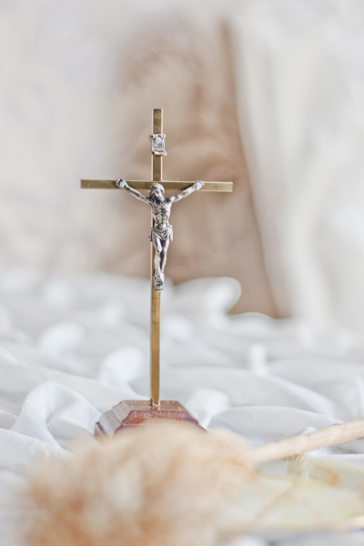 crucifix posé sur un drap froissé blanc