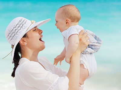 mère souriant à son bébé devant la mer
