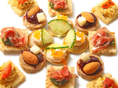 petits canapés apéritifs multicolores disposés en étoile sur une assiette blanche