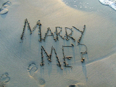 marry me écrit sur le sable d'une plage