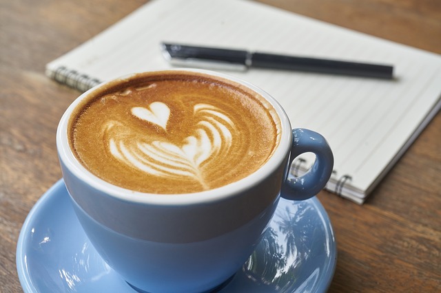 Tasse de café coeur et bloc note avec un stylo pour rédiger ses voeux de mariage