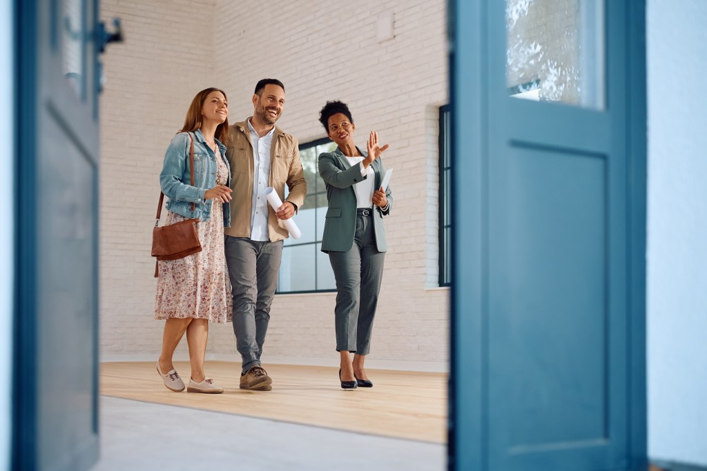 Real estate agent taking a couple through a home showing