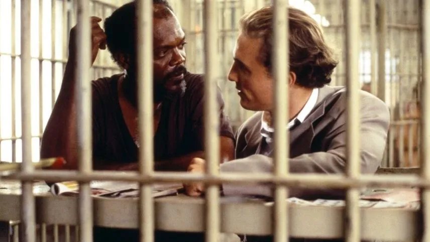 Matthew McConaughey as Jake Brigance and Samuel L. Jackson as Carl Lee Hailey discussing legal strategy through jail bars in A Time to Kill.