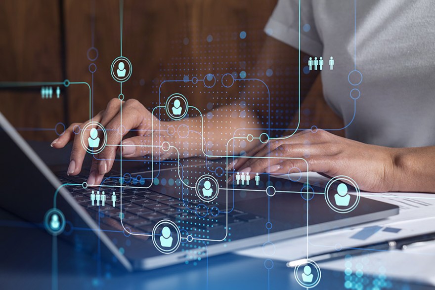 Hands of woman hr specialist is typing the keyboard in the internet to find the best candidates to create international network in recruitment process. Casual wear. Social media hologram icons.