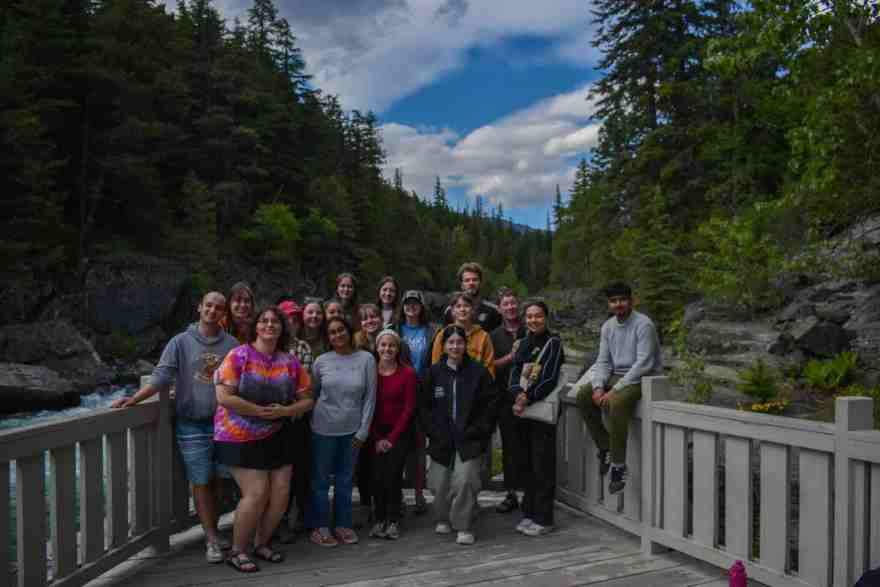 A group photo of NCHC's UReCA national editors and production team stand together at Glacier National Park.