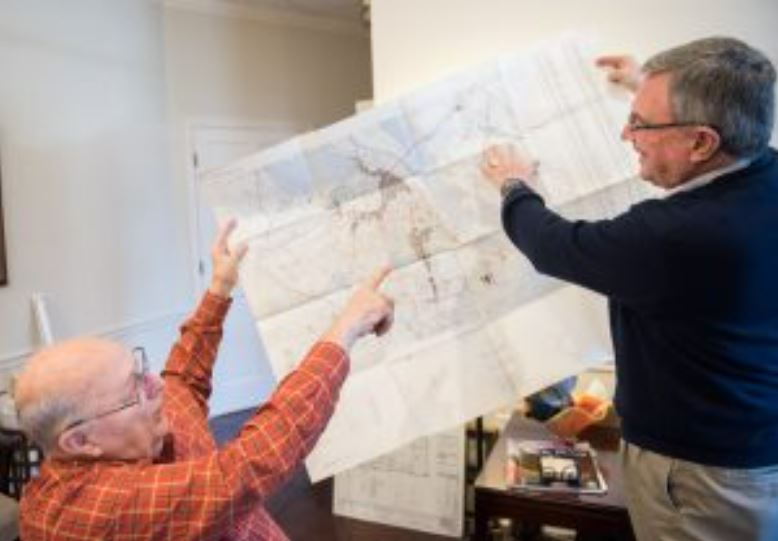 Bill Gauntt, sitting, shows Bill Raines the two POW camps in Hanoi where he was held after his plane was shot down during the Vietnam War in the 1970s.