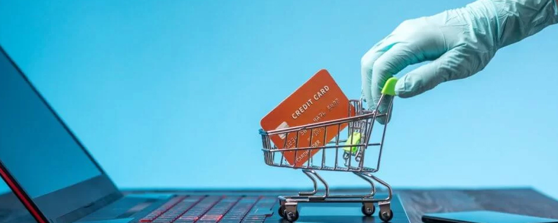 Mão com luvas de médico levando um carrinho de compras em computador