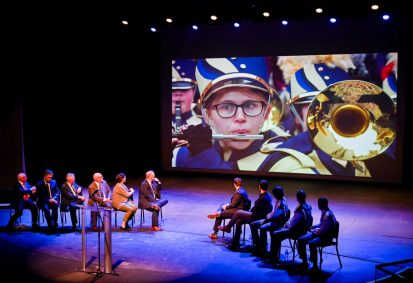 London Parade Invitation-23 Representatives from the London Parade office and the city of London along with UTC representatives, watch footage of the London Parade Wednesday, March 22, 2023 in the Hayes Concert Hall before presenting the Marching Mocs with their official invitation to participate in the London New Year’s Day Parade.