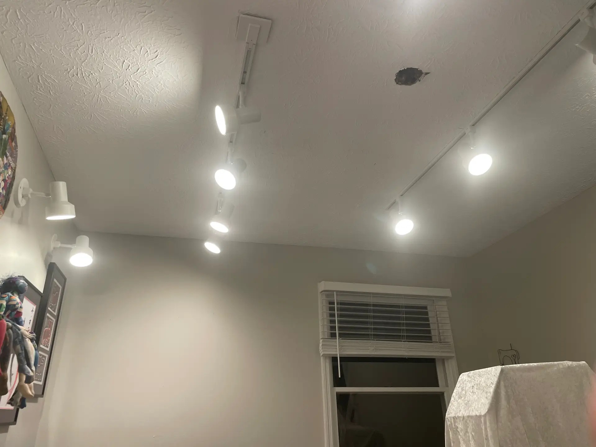 Illuminated track lights installed across the quilting studio ceiling