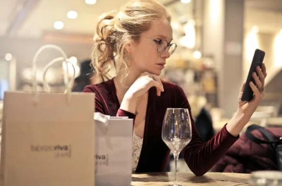 woman wearing stylish glasses while looking at phone for phygitaloptions