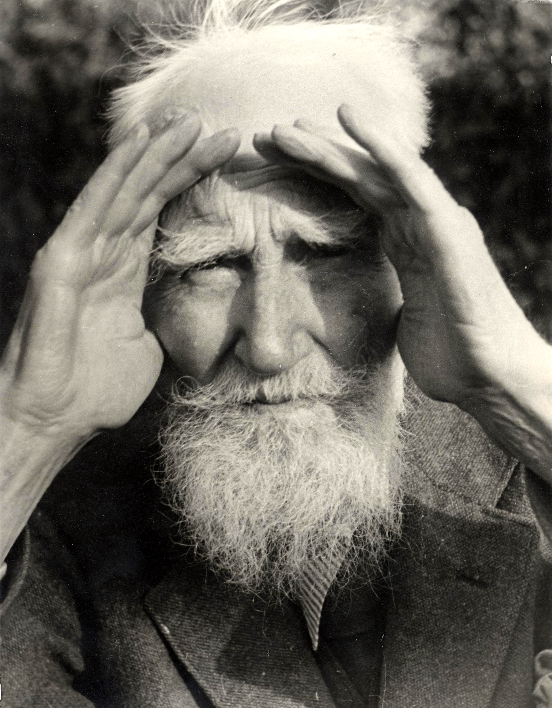 George Bernard Shaw shading his eyes with his hands
