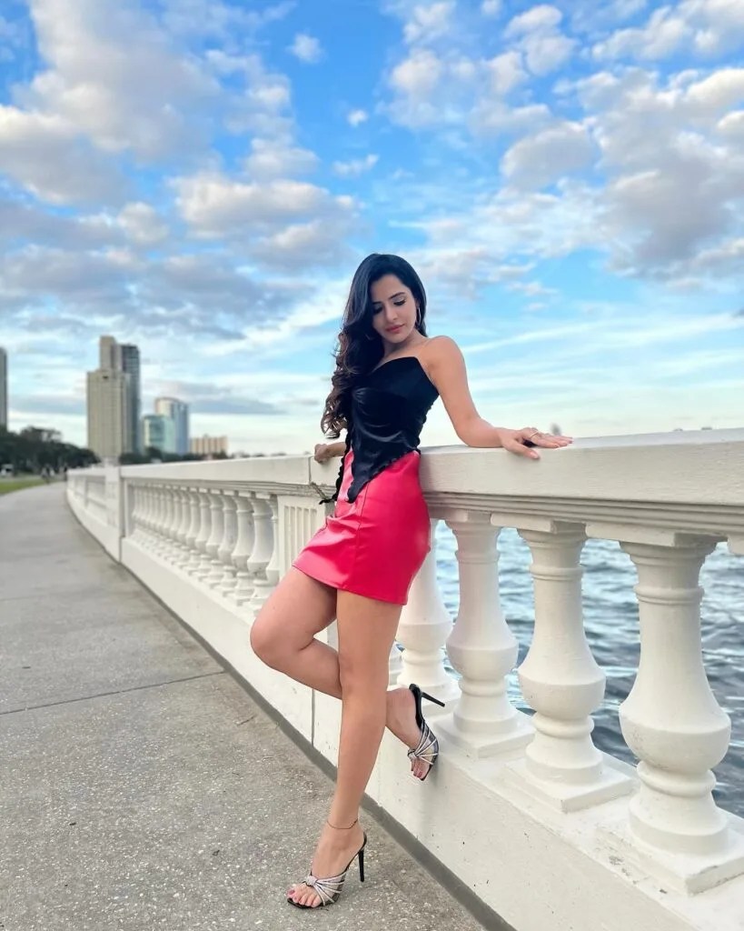 Ashu Reddy looks gorgeous in a chic black top paired with a vibrant red mini skirt