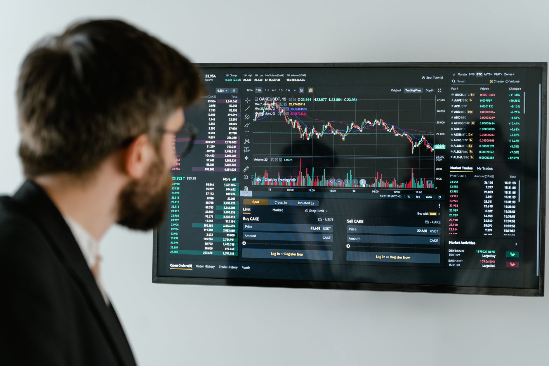 man in black suit standing in front of black monitor