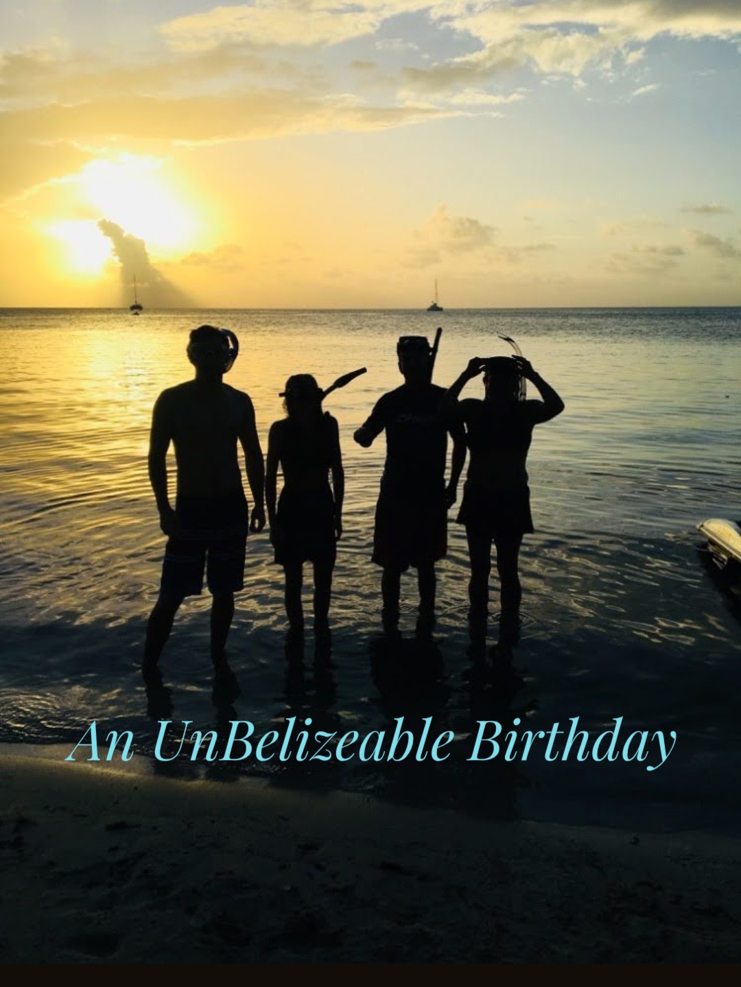 Sunset silhoutte of four people in snorkels standing in the ocean.