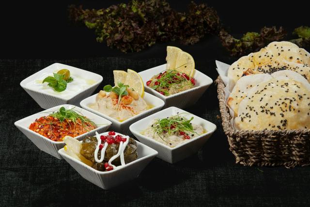 A delectable assortment of Middle Eastern dips and bread with fresh herbs and spices.